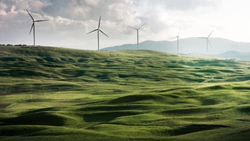 Green hills with wind turbines on the horizon